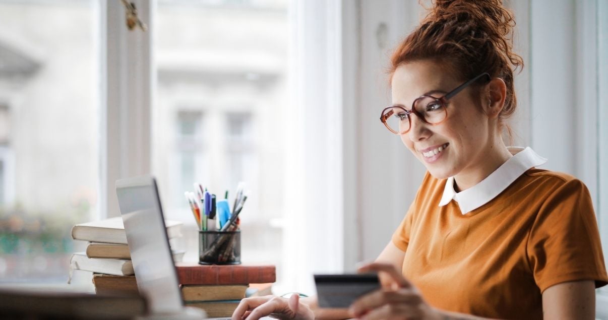Mujer feliz pagando con su link de pago a través de una computadora